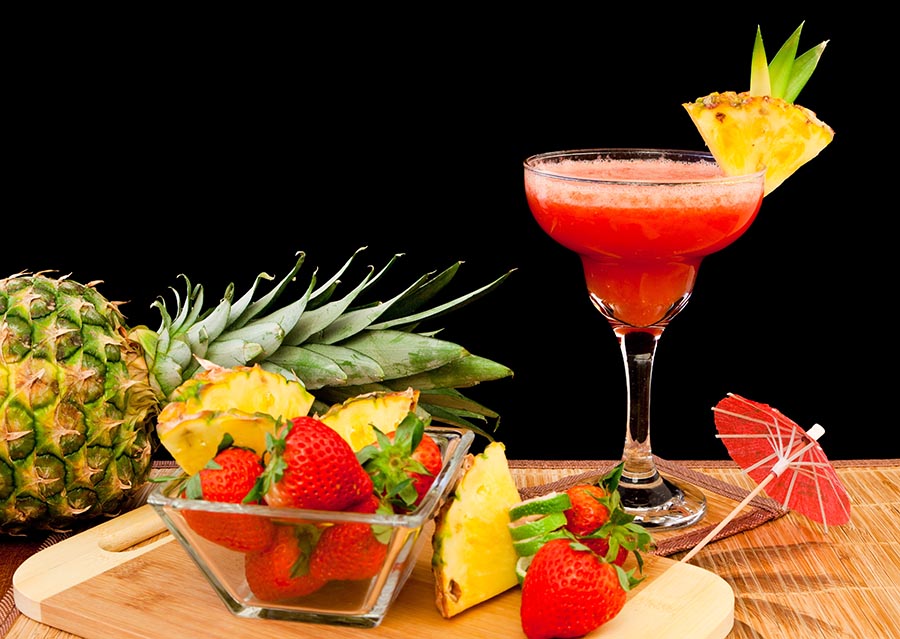 Cóctel de frutas tropicales con frutas a su alrededor